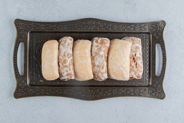 Free photo cookie wrappings on an ornate tray on marble background.