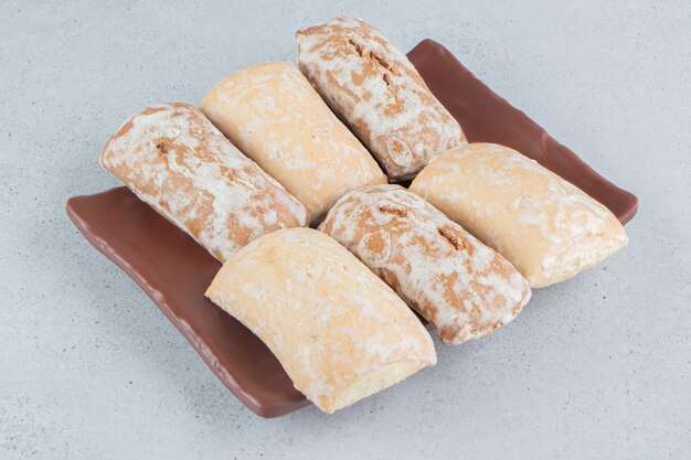 Cookie wrappings on a platter on marble background.