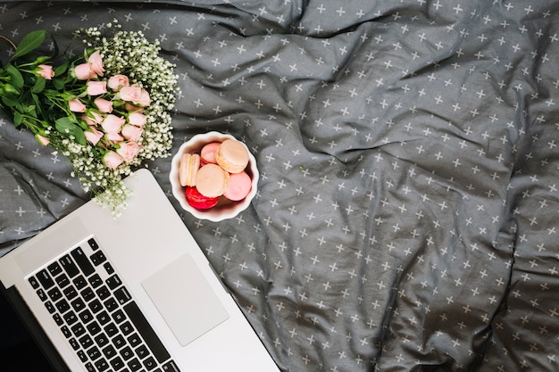 Cookies and bouquet near laptop