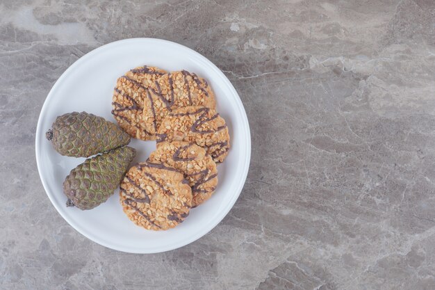 Cookies and pine cones on a platter on marble