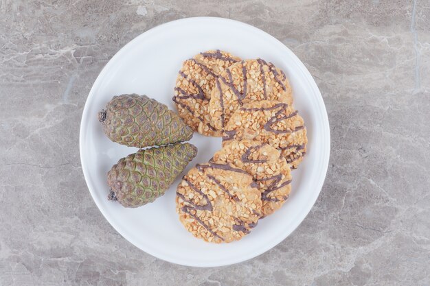 Cookies and pine cones on a platter on marble