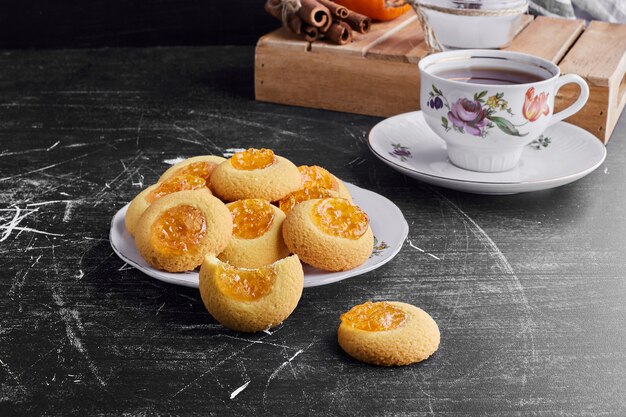 Cookies with apricot confiture with a cup of tea. 