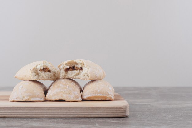 Cookies with filling bundled on a board on marble