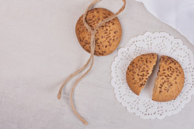 Cookies with sesame seeds on white surface.