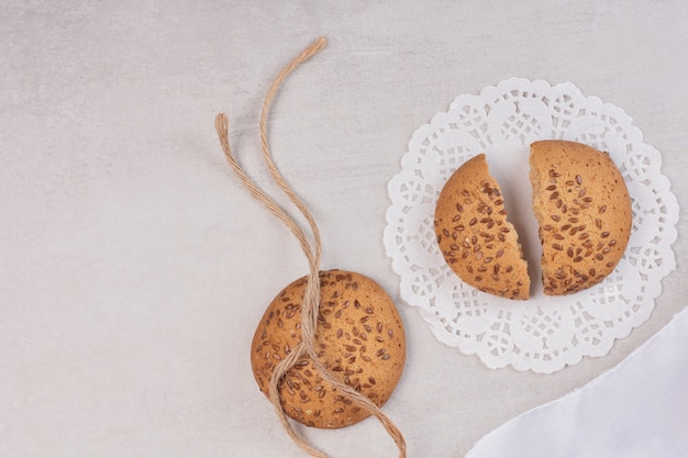 Cookies with sesame seeds on white surface.