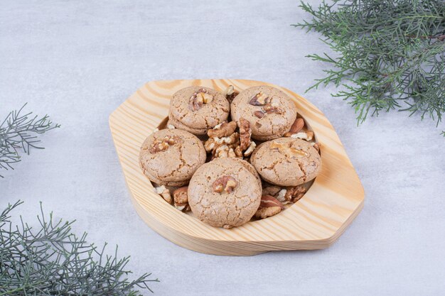 Cookies with walnut kernels on wooden plate.