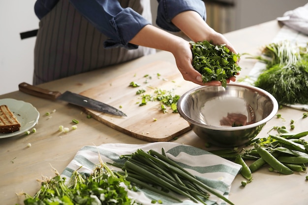 Free photo cooking. chef is cutting greens in the kitchen