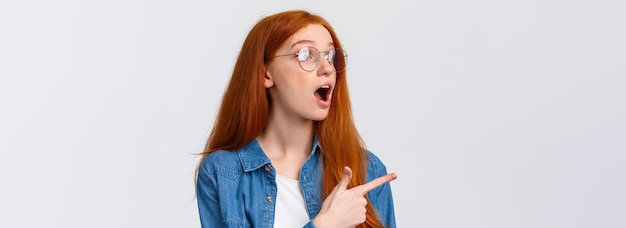 Free photo cool take a look closeup portrait fascinated and excited cute redhead woman in glasses checking out