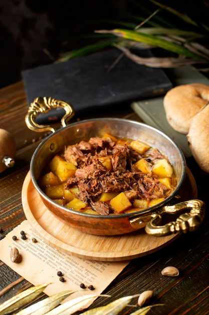 Copper pan with potato and lam stew cooked in oil