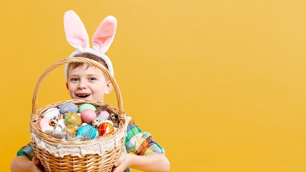 Copy-space boy with basket full of painted eggs