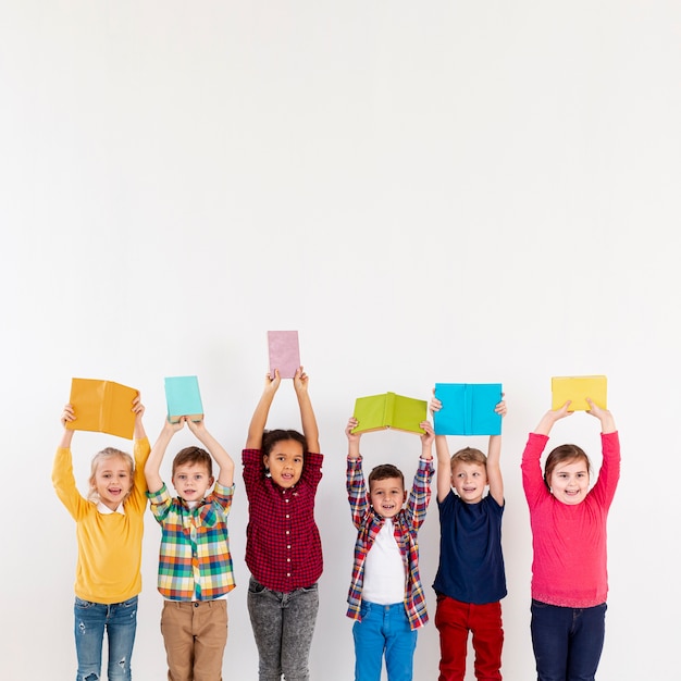 Copy-space childrens holding books above heads