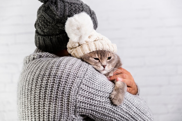 Free photo copy-space male and cat wearing fur cap