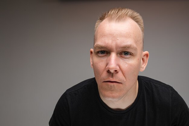 Copy-space photo of serious Caucasian man in black shirt furrowing his brow