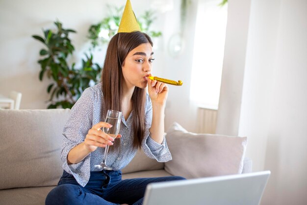 Copy space shot of a cheerful young woman having a birthday celebration event with a friend over a video call She is making a celebratory toast with a glass of white wine towards laptop camera