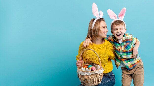 Copy-space smiley boy and mom with painted eggs