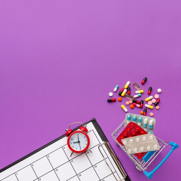 Copy-space toy cart with clock and pills beside