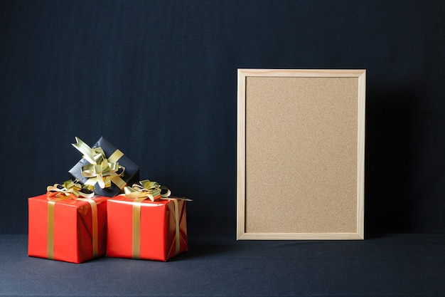 Corkboard and Christmas gift boxes with copy space isolated on a dark background