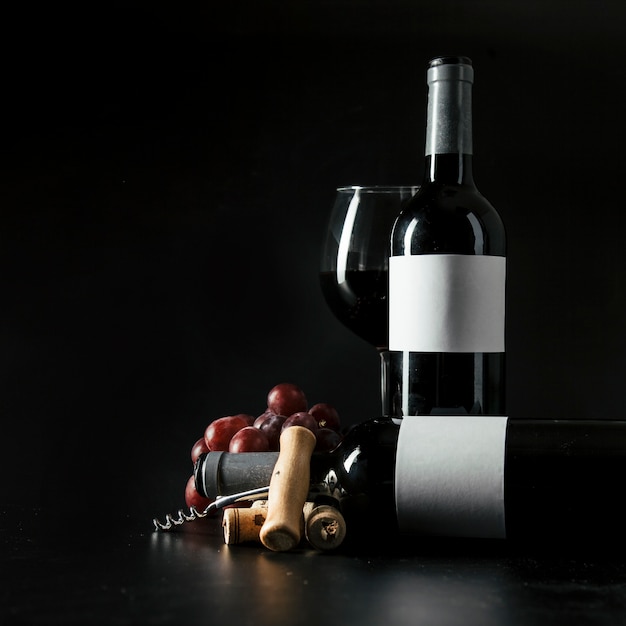 Free Photo corkscrew and grape near bottles and wineglass