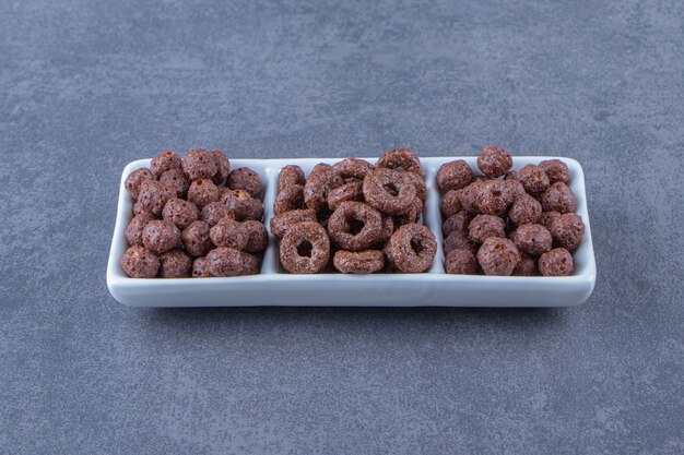 Corn balls and corn rings on a bowl, on the marble background. High quality photo