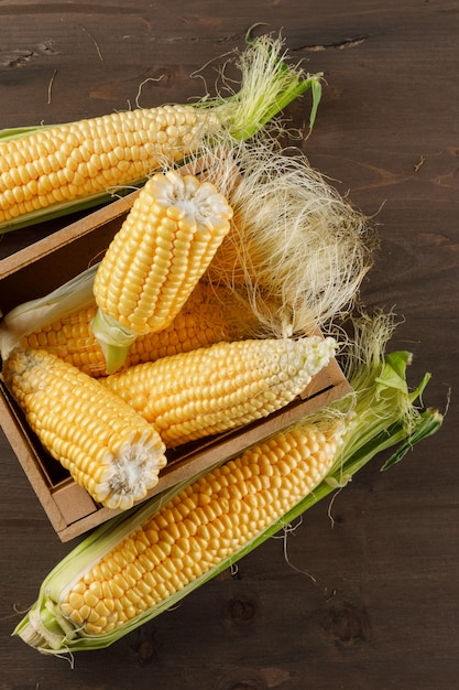 Corn cobs in a wooden box high angle view on a wooden table