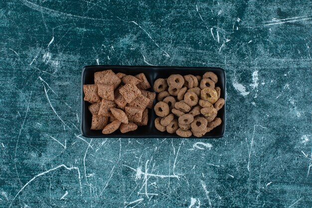 Corn pads and corn rings in a bowl , on the blue table. 