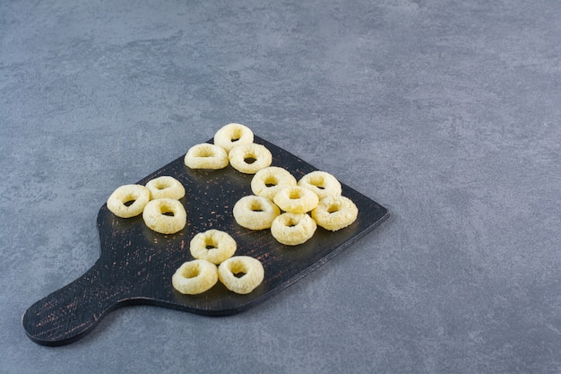 Free photo corn rings on a cutting board , on the marble surface