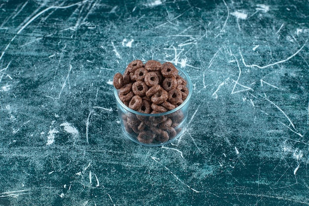 Corn rings in a glass bowl , on the blue table. 