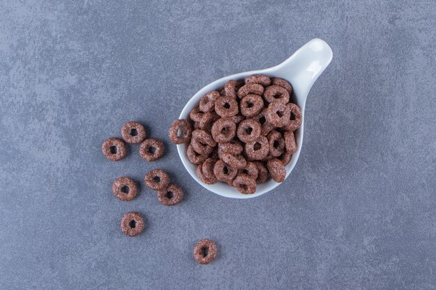 Corn rings in a spoon, on the marble table.