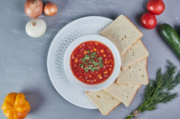 Free photo corn soup in tomato sauce with a bunch of dill.