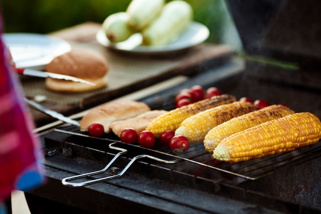 Corn, tomatoes on grill. Barbecue party.