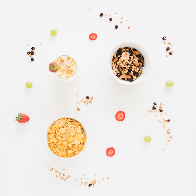 Cornflakes; dried fruits with strawberry and grapes on white background