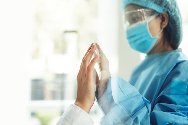 Free photo coronavirus doctor touching family hand through a glass window