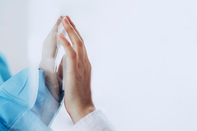 Free photo coronavirus doctor touching family hand through a glass window