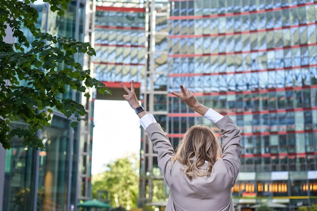 Free Photo corporate people rear view of businesswoman raising hands up in celebration triumphing achieve goal