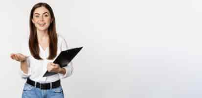 Free photo corporate woman businesswoman holding clipboard with documents in office smiling at camera white background