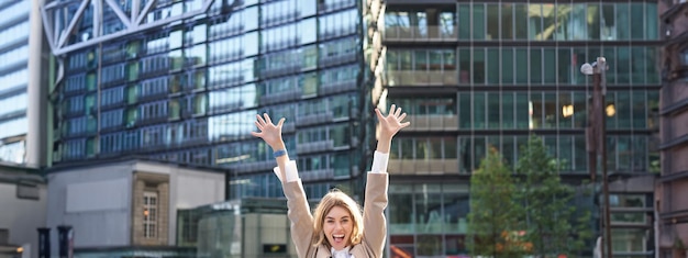 Free Photo corporate woman celebrating her victory outside on street happy businesswoman raising hands up and