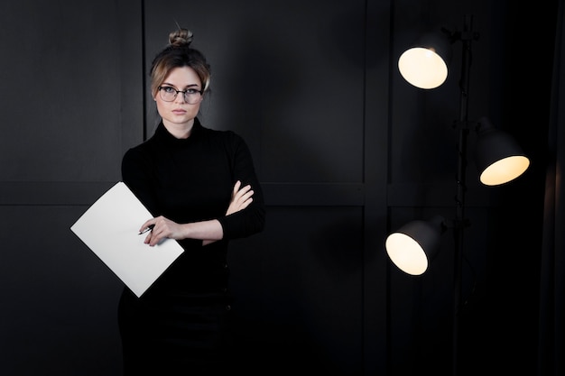 Corporate young woman with eyeglasses holding papers