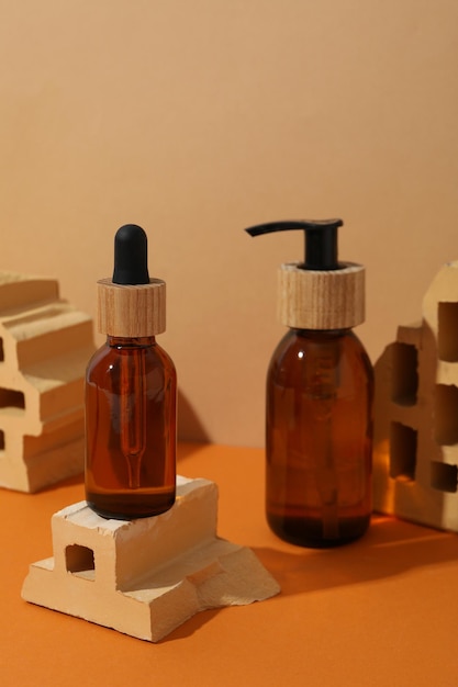 Free Photo cosmetic bottles and bricks on orange background