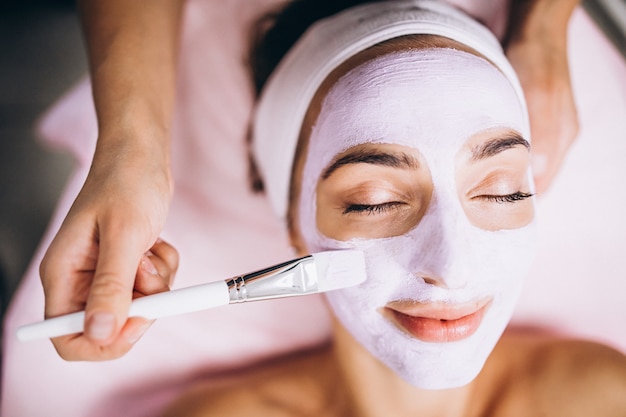 Free Photo cosmetologist applying mask on a face of client in a beauty salon