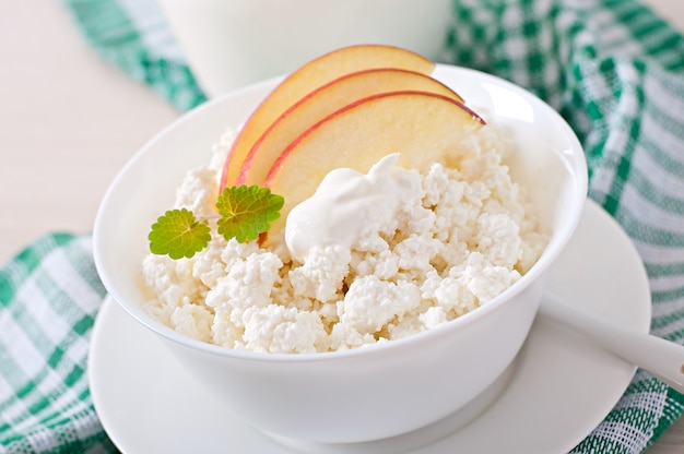 Cottage cheese with apples and sour cream for breakfast close up