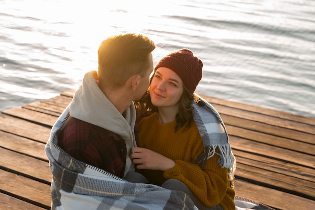 Free Photo couple in affectionate attitude wearing plaid blanket