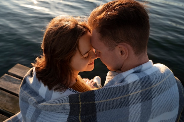 Free Photo couple in affectionate attitude wearing plaid blanket