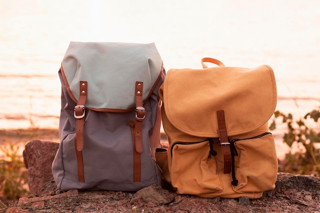 Couple backpacks on rocks at sunset