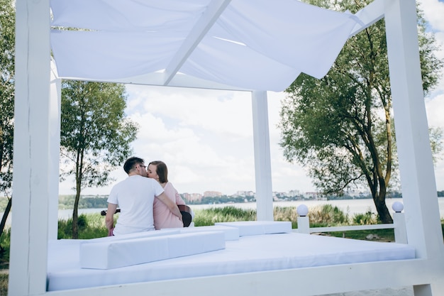 Free photo couple of backs sitting on a bed kissing