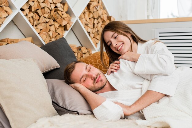 Couple in bed wearing bathrobes waking up