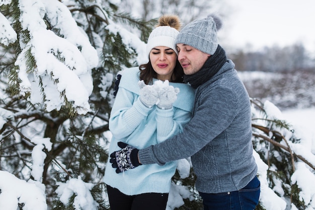 Free photo couple blowing at snow