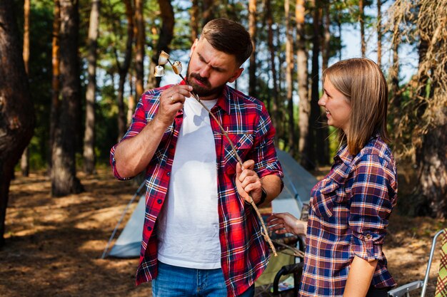 Couple camping eating marshmellow