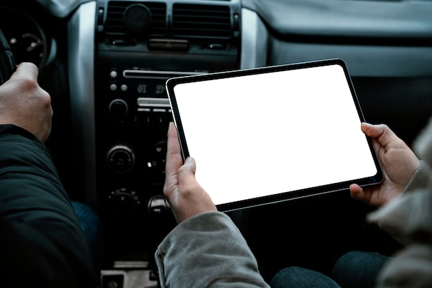 Couple in the car consulting tablet while on a road trip