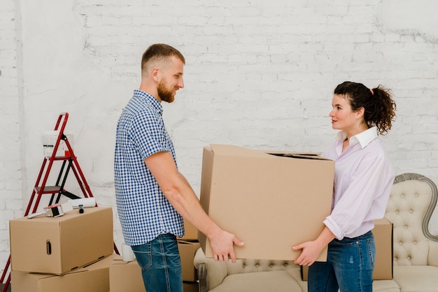 Free photo couple carrying carton box