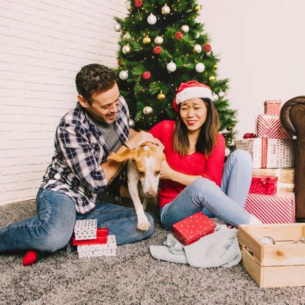 Couple celebrating christmas with dog at home